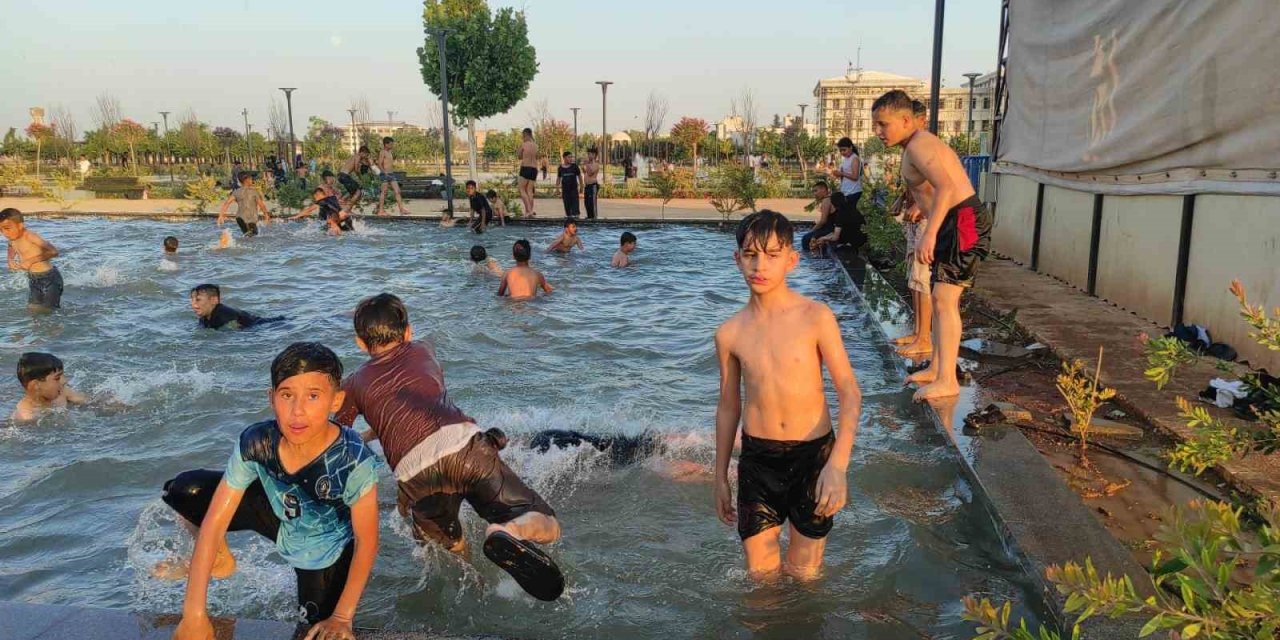 Urfa’da sıcaktan bunalan çocuklar süs havuzunda serinledi