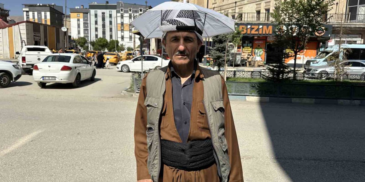 Yüksekovalı vatandaş kafa şemsiyesiyle güneşten korunuyor