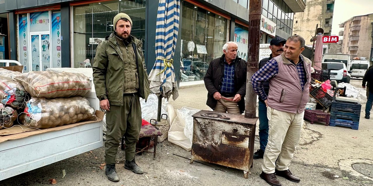 Yüksekova’da bir seyyar satıcı ısınmak için tezgâhının yanına soba kurdu