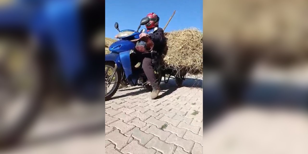 Motosikletin arkasına el arabası bağlayarak üzerinde ot taşıdı