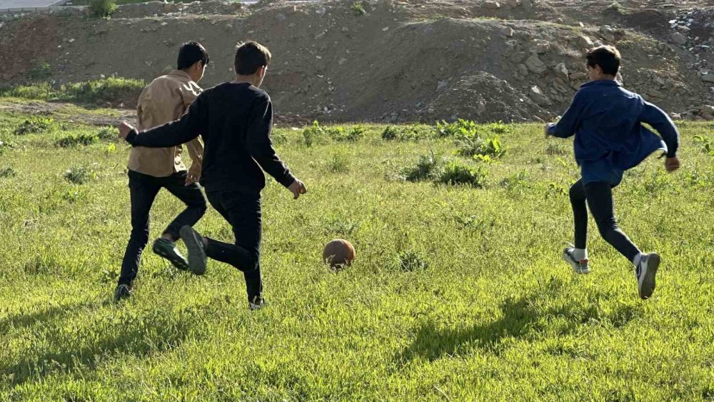 Boş arazide top oynayan çocuklar futbol sahası istiyor
