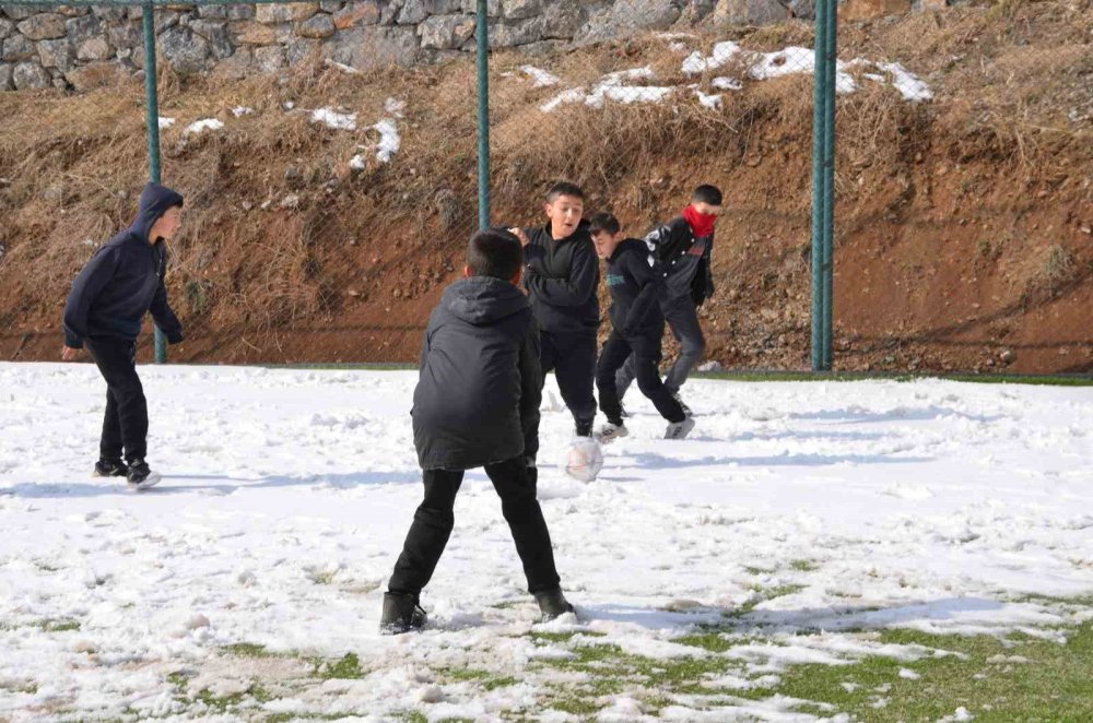 Çocuklar futbol aşkına karlı yolları aşıp halı sahada top oynuyor