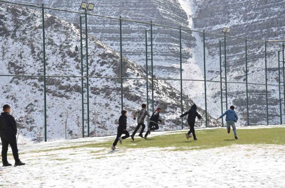 Çocuklar futbol aşkına karlı yolları aşıp halı sahada top oynuyor