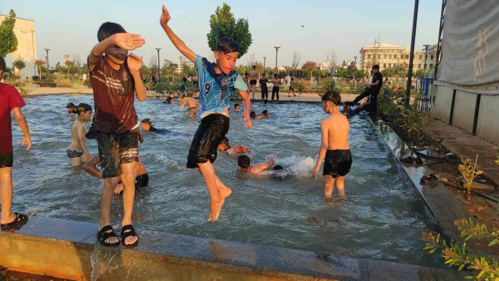 Urfa’da sıcaktan bunalan çocuklar süs havuzunda serinledi