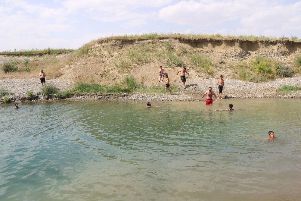 Yüksekova'da sıcaklardan bunalanlar derede serinliyor