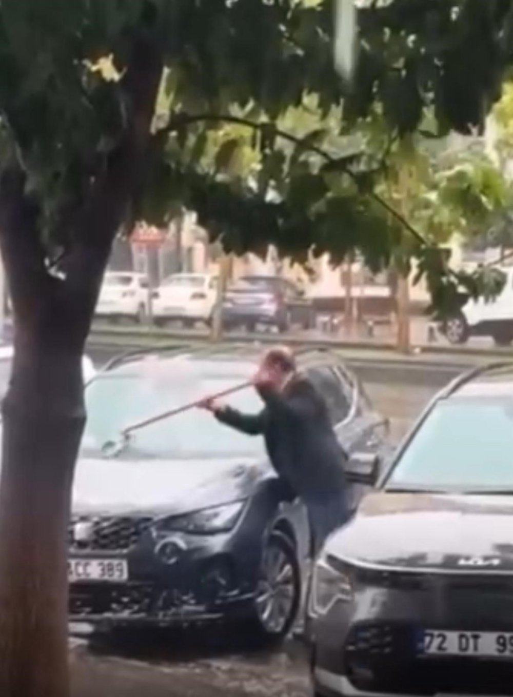 Sağanak yağmur altında arabasını yıkadı