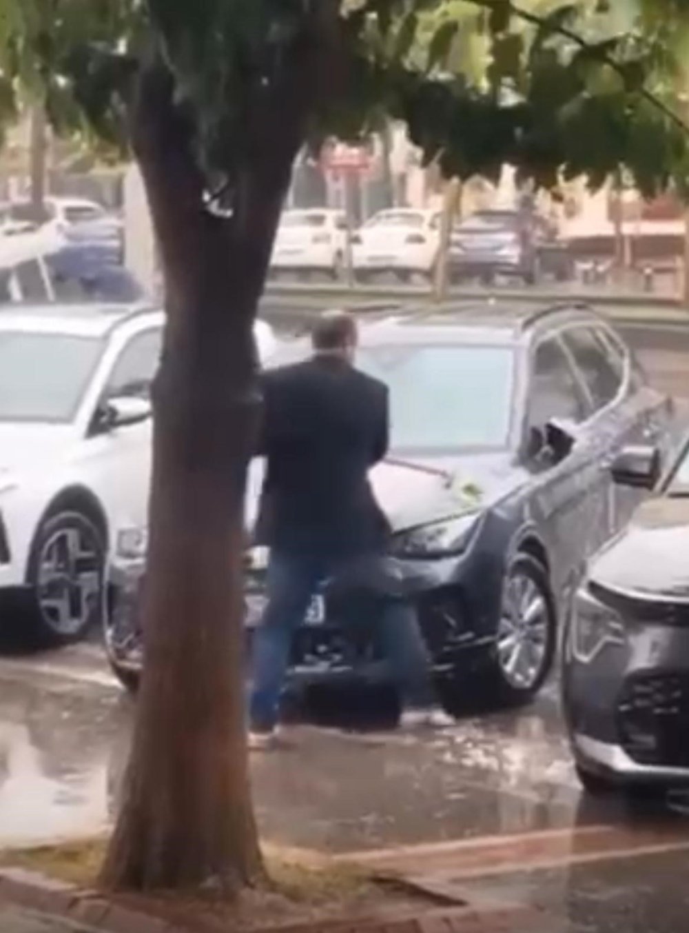 Sağanak yağmur altında arabasını yıkadı