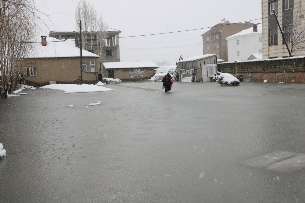 Evinin önünde biriken su nedeniyle çocuklarını sırtında taşıyor